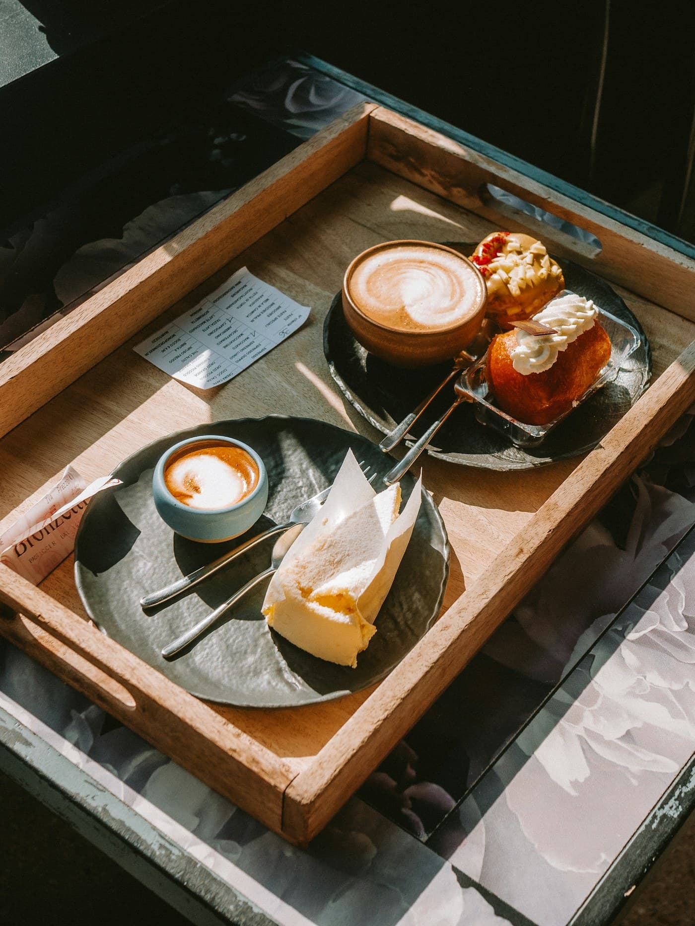 Colazione con caffè e dolci serviti su un vassoio in legno